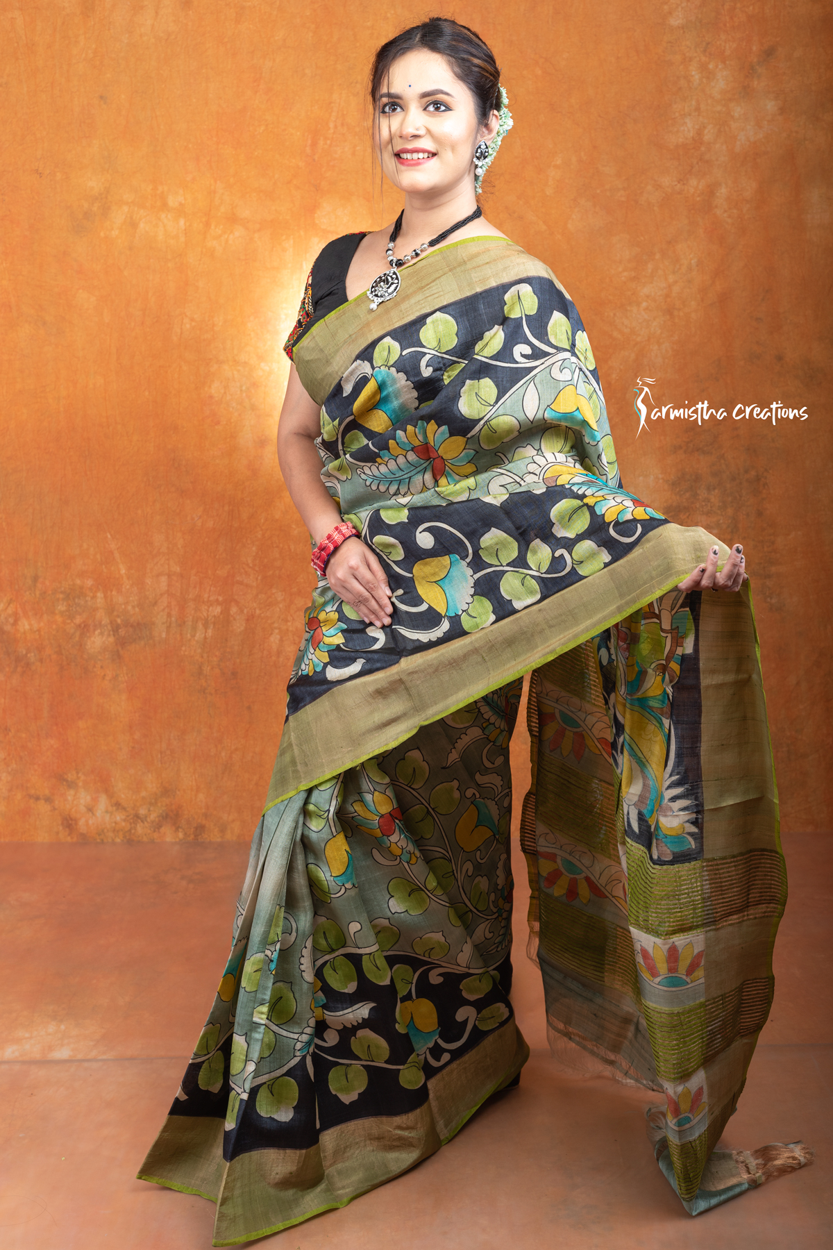 This is a Silk Mark certified zari tussar saree with hand painted kalamkari in multicolour on a pistachio green base.