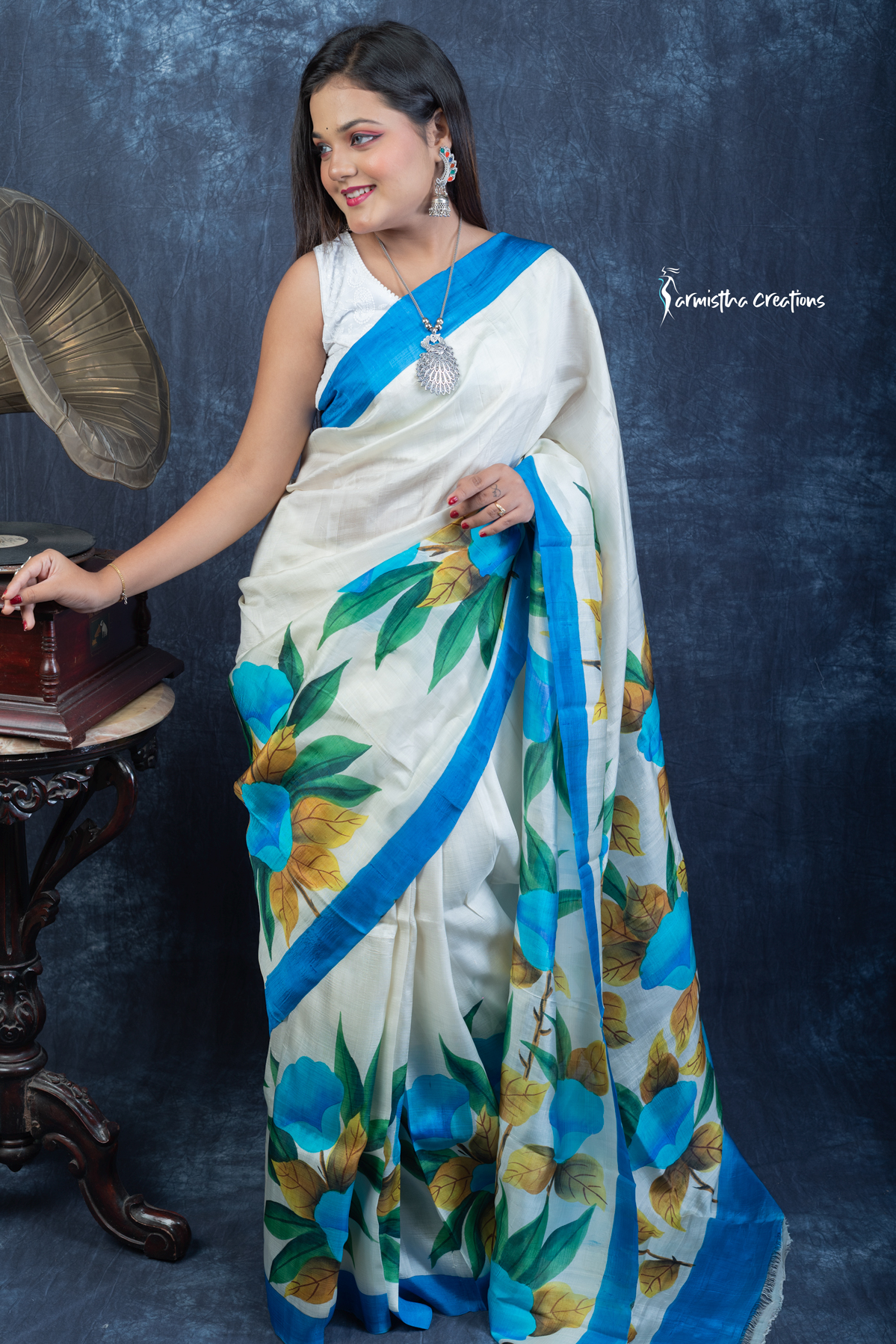 Radiate timeless elegance with Kiss of Red, a pure Bishnupuri silk saree hand-painted in vibrant scarlet with bold white floral motifs. Lightweight, luxurious, and effortlessly stunning — this saree captures passion and tradition in every drape.