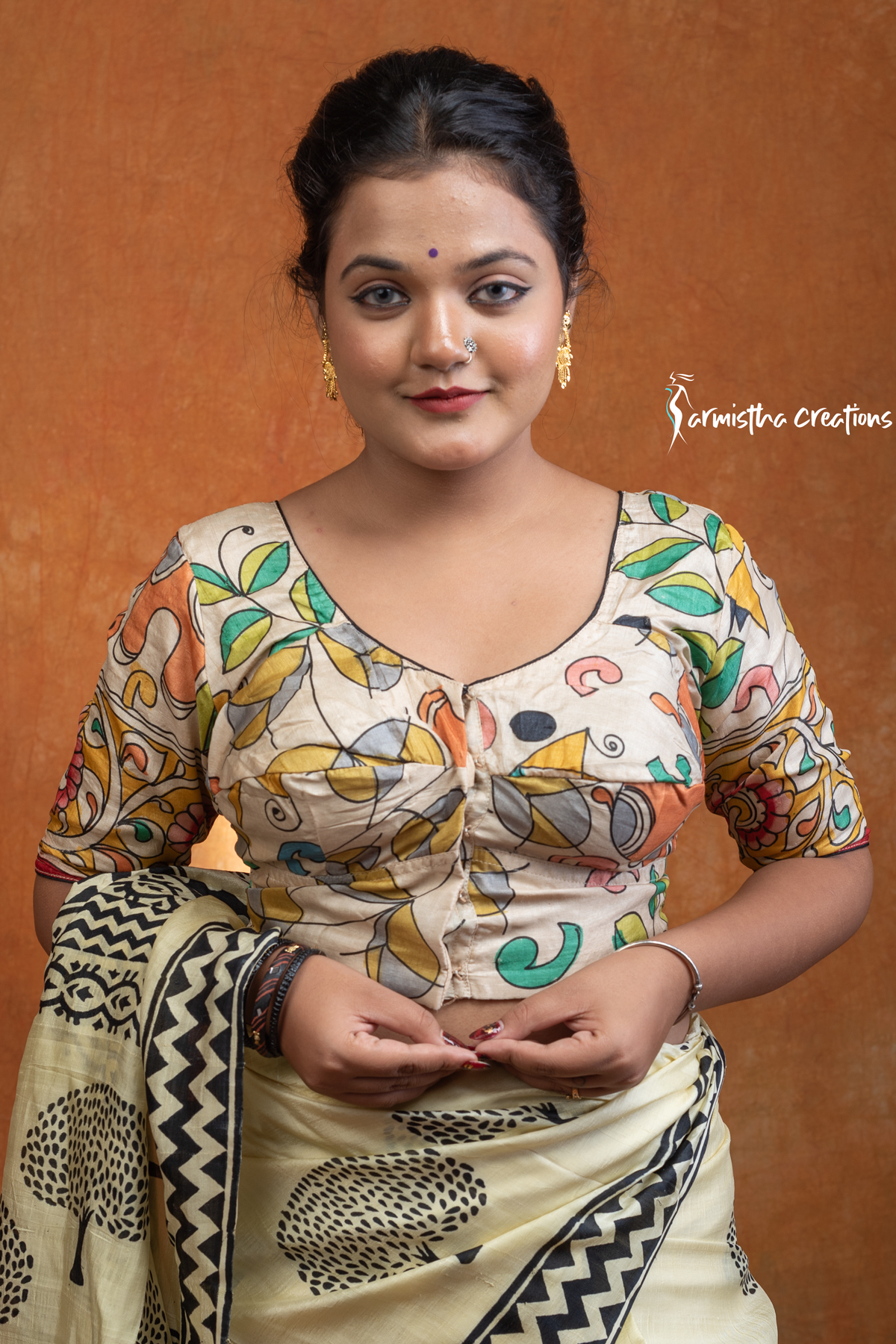 Prakriti is a hand kalamkari ready-stitched blouse inspired by the free spirit of nature. Crafted on a soft cream base, it features flowing multicolored vines and motifs in mustard, green, teal, and coral — a harmonious play of earthy and vibrant tones.