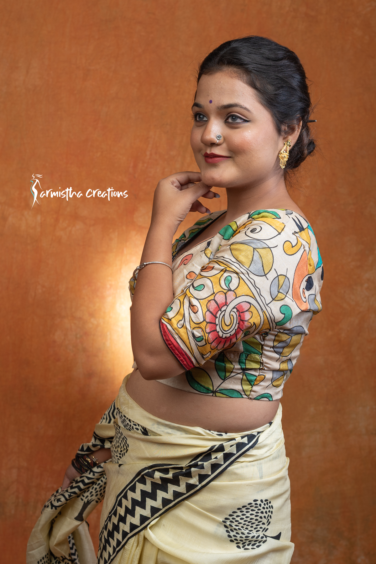 Prakriti is a hand kalamkari ready-stitched blouse inspired by the free spirit of nature. Crafted on a soft cream base, it features flowing multicolored vines and motifs in mustard, green, teal, and coral — a harmonious play of earthy and vibrant tones.