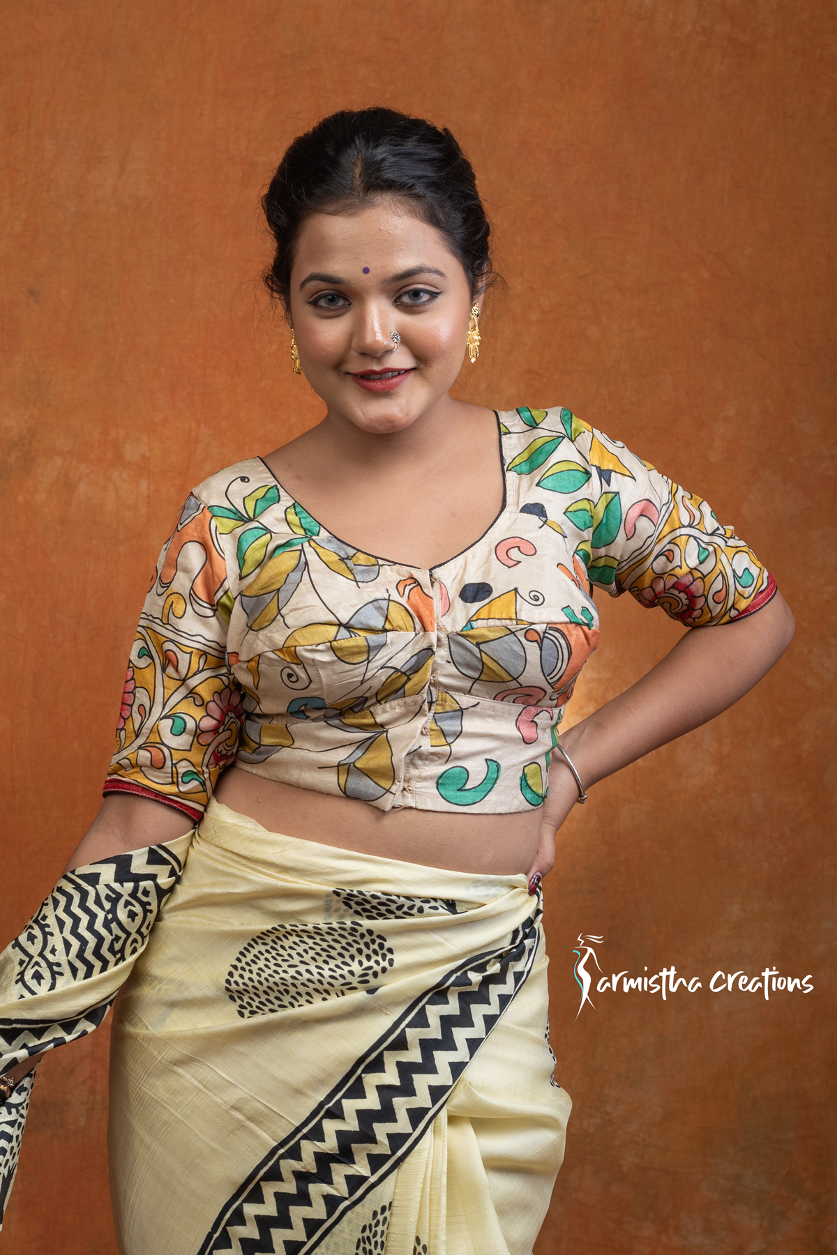 Prakriti is a hand kalamkari ready-stitched blouse inspired by the free spirit of nature. Crafted on a soft cream base, it features flowing multicolored vines and motifs in mustard, green, teal, and coral — a harmonious play of earthy and vibrant tones.