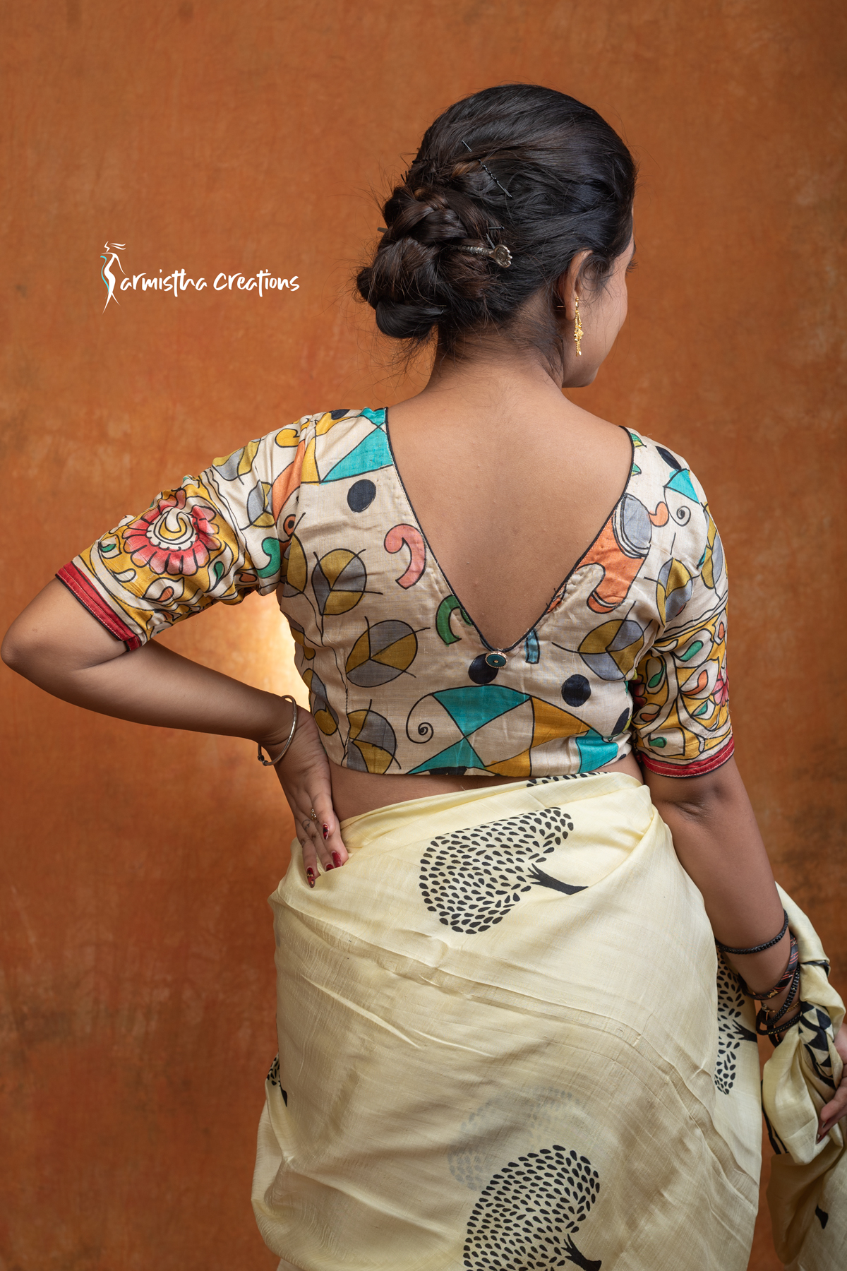 Prakriti is a hand kalamkari ready-stitched blouse inspired by the free spirit of nature. Crafted on a soft cream base, it features flowing multicolored vines and motifs in mustard, green, teal, and coral — a harmonious play of earthy and vibrant tones.
