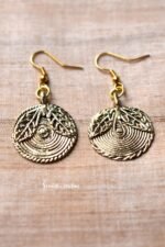 Tribal dokra earrings featuring a textured, circular design with leaf motifs