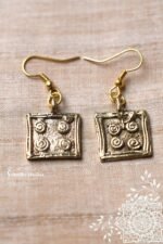 Tribal dokra earrings featuring square charms with a spiral embossed design.